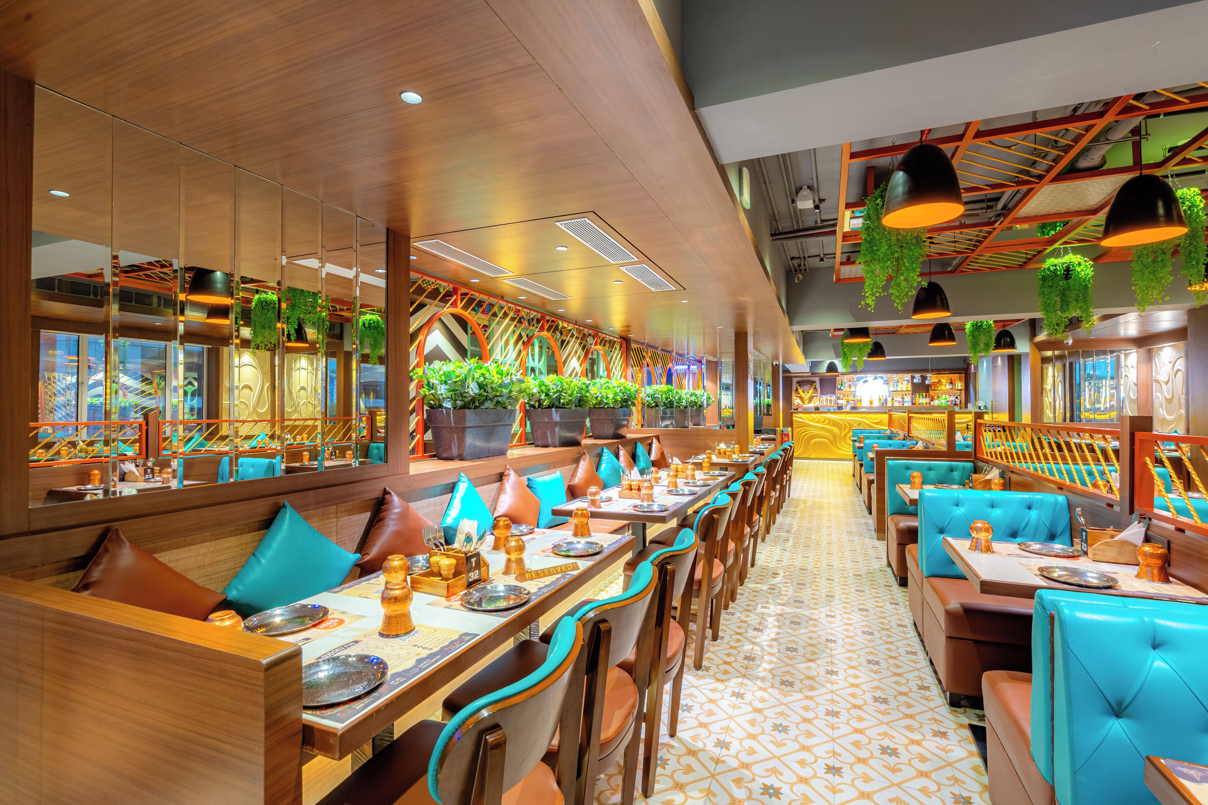 A restaurant with booths and tables, some with blue cushions, and a patterned floor.