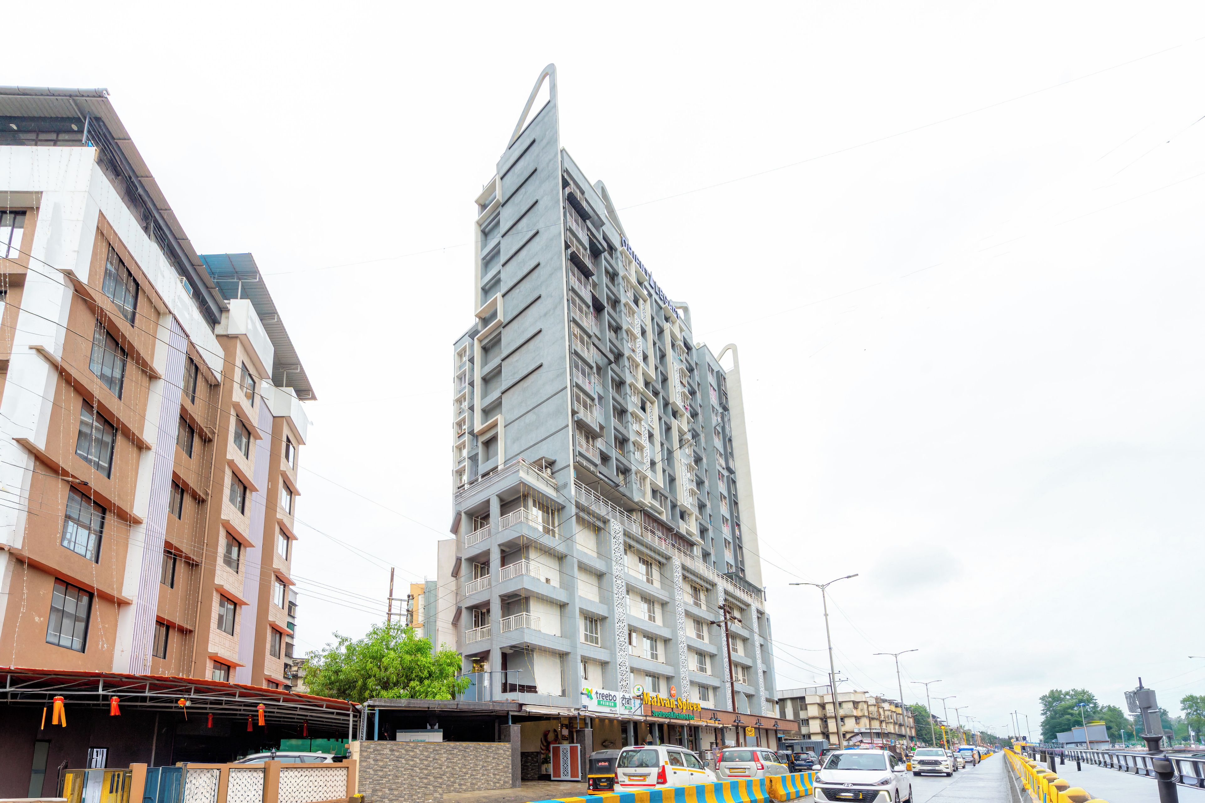 A multi-story building with a modern architectural design, featuring balconies and a prominent entrance.