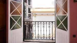 An open door with a wrought iron gate leading to a balcony with a view of buildings. - tangier medina apartments (Tanger)