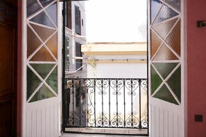 An open door with a wrought iron gate leading to a balcony with a view of buildings. - tangier medina apartments (Tanger)