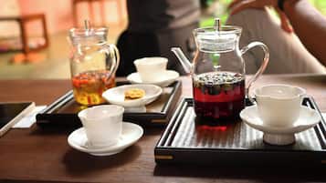 A tray with a glass pitcher and cups, likely containing tea, on a wooden table.
