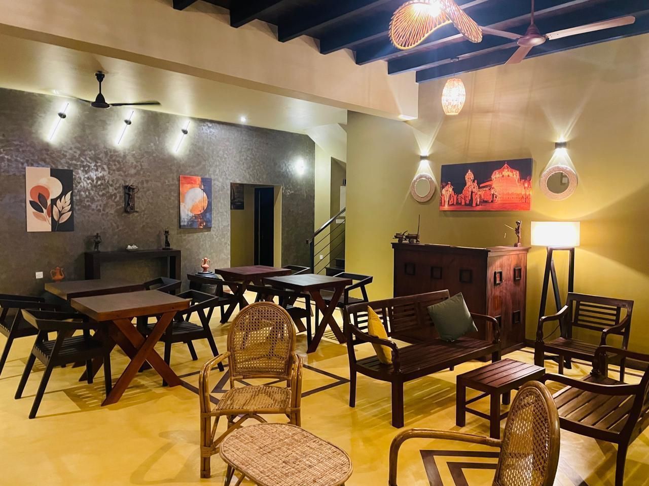 A dining area with wooden furniture, a staircase, and wall-mounted artwork.