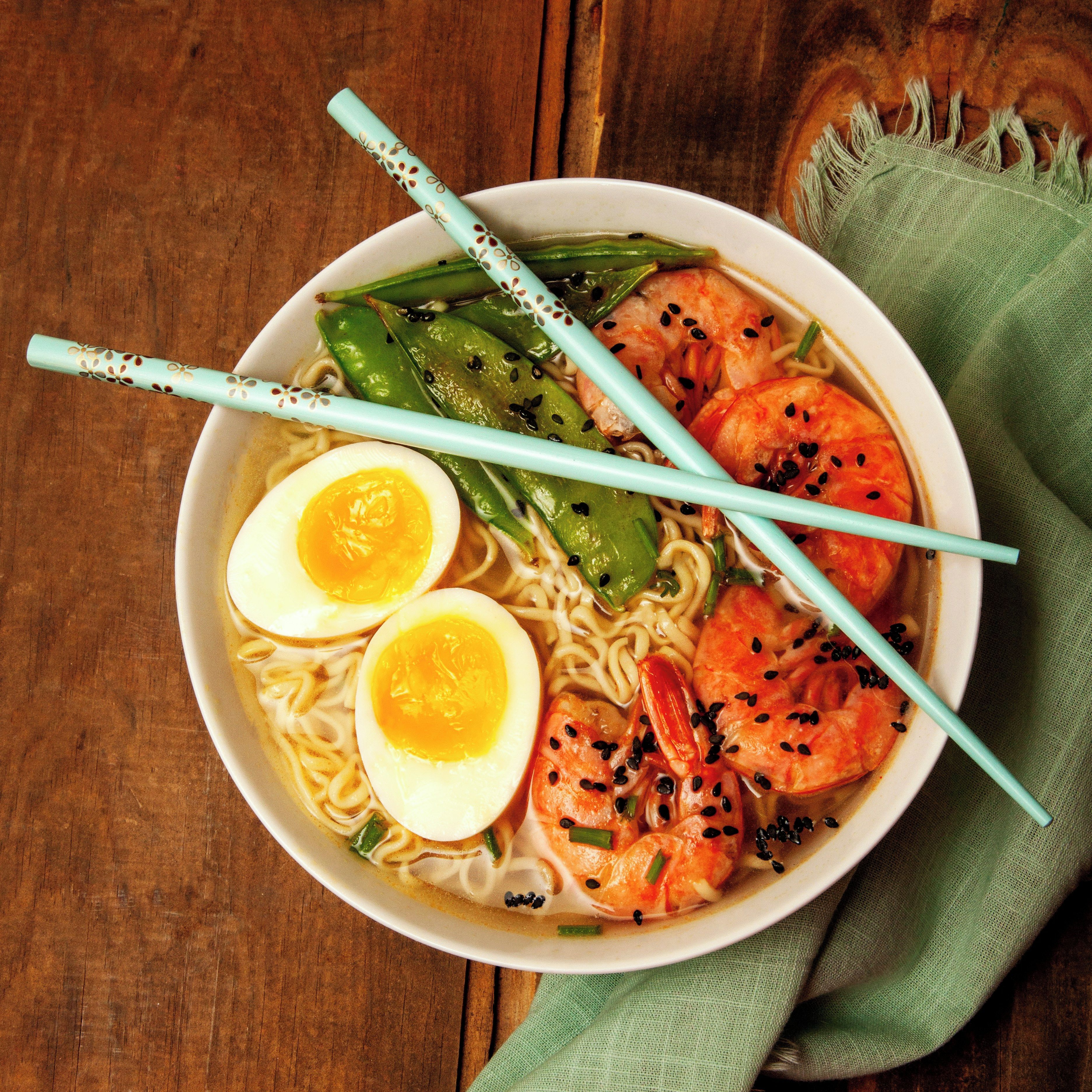 Un bol de ramen amb fideus, gambes, ou i verdures.