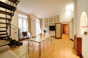 A modern interior with a staircase, dining table, chairs, and a TV. - BuddyRent - Private Pool - Trastevere - 6 (Roma)
