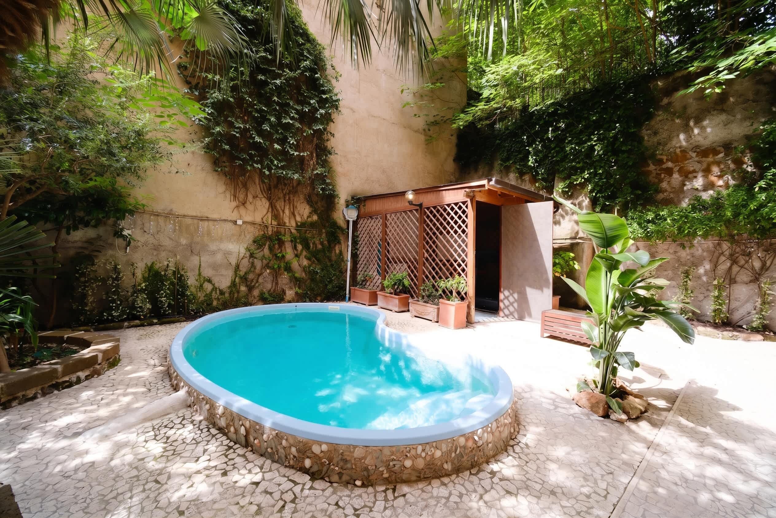 A swimming pool with a stone border, surrounded by potted plants and a wooden pergola.