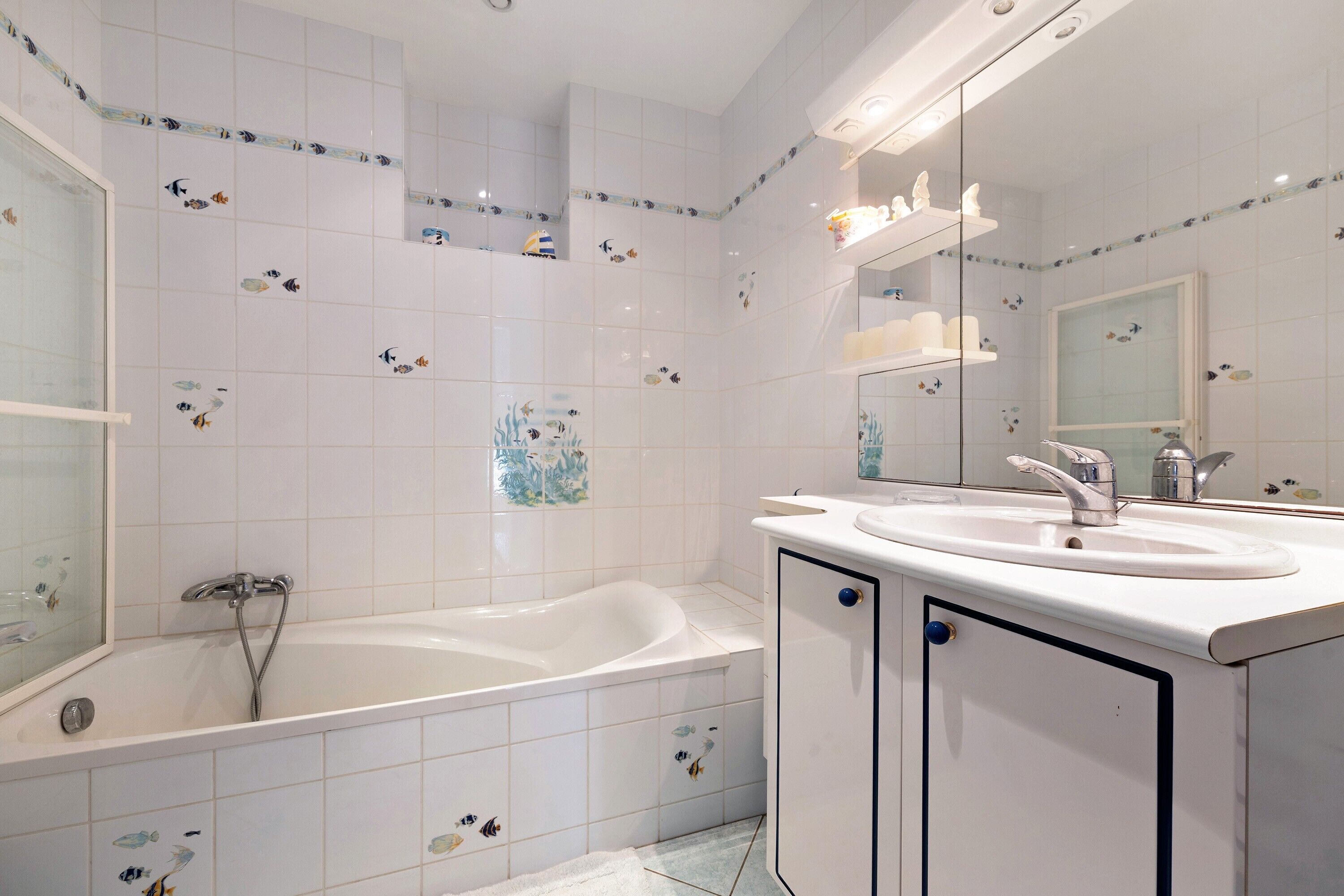 A bathroom with a bathtub, two sinks, and a mirror.