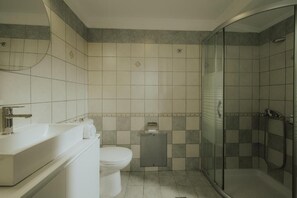 Een douche, handdoeken, zeep, toiletpapier