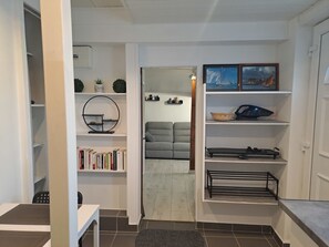 Een moderne woonkamer met een bank, een boekenkast, een rond bordplankje en een kleine tafel.