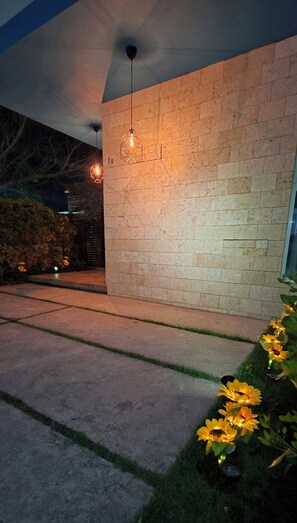 A modern building with a stone facade, a geometric light fixture, and a pathway leading to the entrance. - Sunflower Villa Punta Cana (Punta Cana)