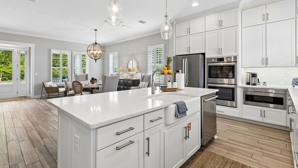 Una cocina moderna con armarios blancos, electrodomésticos de acero inoxidable y una isla grande.