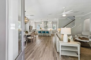 A modern kitchen with a dining area, a staircase, and a living room with a sofa and coffee table. - Sunrise on First - Close walk to beach (Fernandina Beach)