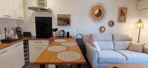 Eine kleine Küche mit einem Holztisch, einer Couch und Wanddekoration.