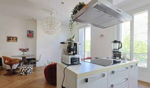 Eine moderne Küche mit Einbauherd, Mixer und großem Fenster.