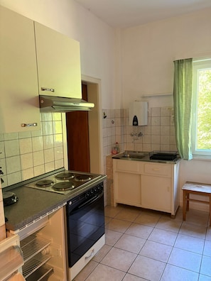 A compact kitchen with a stove, oven, and a small sink.
