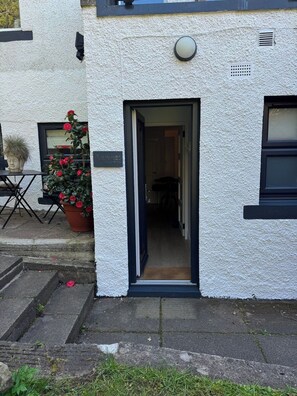A white building with a door leading to an interior hallway.