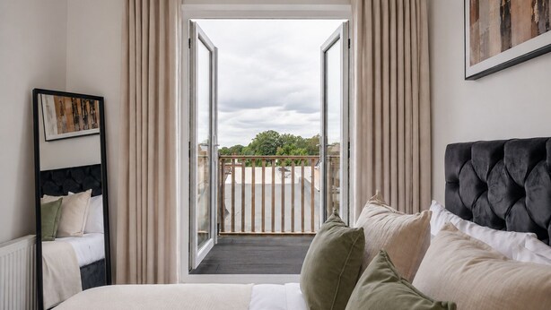 A bedroom with a bed, a window, and a balcony. - Stylish 1BR Penthouse with Balcony - City Centre near Cliffs Pavillion (Southend-on-Sea)