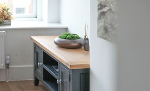 A kitchen with a wooden countertop, a dark cabinet, a green plant, and a vase with sticks. - 1BR Penthouse with Balcony - City Centre near Cliffs Pavillion (Southend-on-Sea)