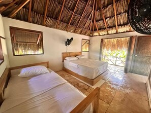 A room with two beds, a thatched roof, a fan, and a window with a view. - Orika del Mar  (Rosario Islands)