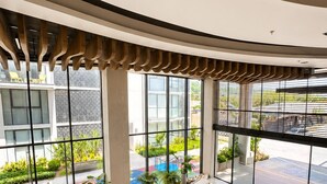 Eine großzügige Lobby mit großen Fenstern, einer gewölbten Decke und einer kleinen Außenbereich-Sitzgelegenheit mit Pflanzen.