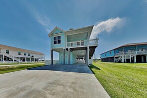 A two-story building with a covered walkway and a balcony. - Tiki Pool Club (Galveston)