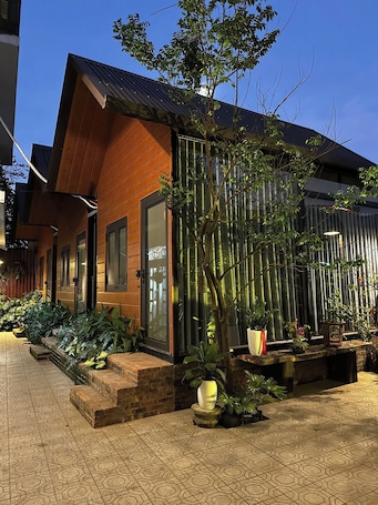 Un edificio moderno con fachada de madera, ventanas amplias y un jardín de bambú.. Gac homestay
