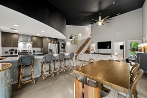 Eine moderne Küche mit Essbereich, einer Treppe und einem Wohnzimmer.