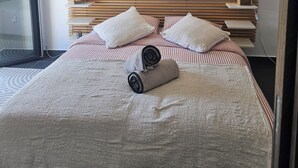 A modern bedroom with a bed, pillows, a bedside table, a lamp, and two wall decorations. - Casa Avvena 2 - Bed and breakfast with breakfast (Lecci)