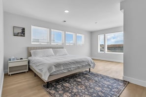 A bedroom with a bed, bedside table, and a window.