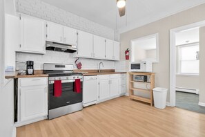 A modern kitchen with white cabinets, a stainless steel stove, a microwave, and a wooden countertop. - Private Pool, 3BR Jersey Shore Oasis (Seaside Heights)