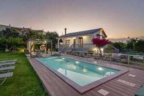 A swimming pool with a wooden deck, a covered patio, and a house with a stone facade. - Santy Villa - Gerani (Gerani)