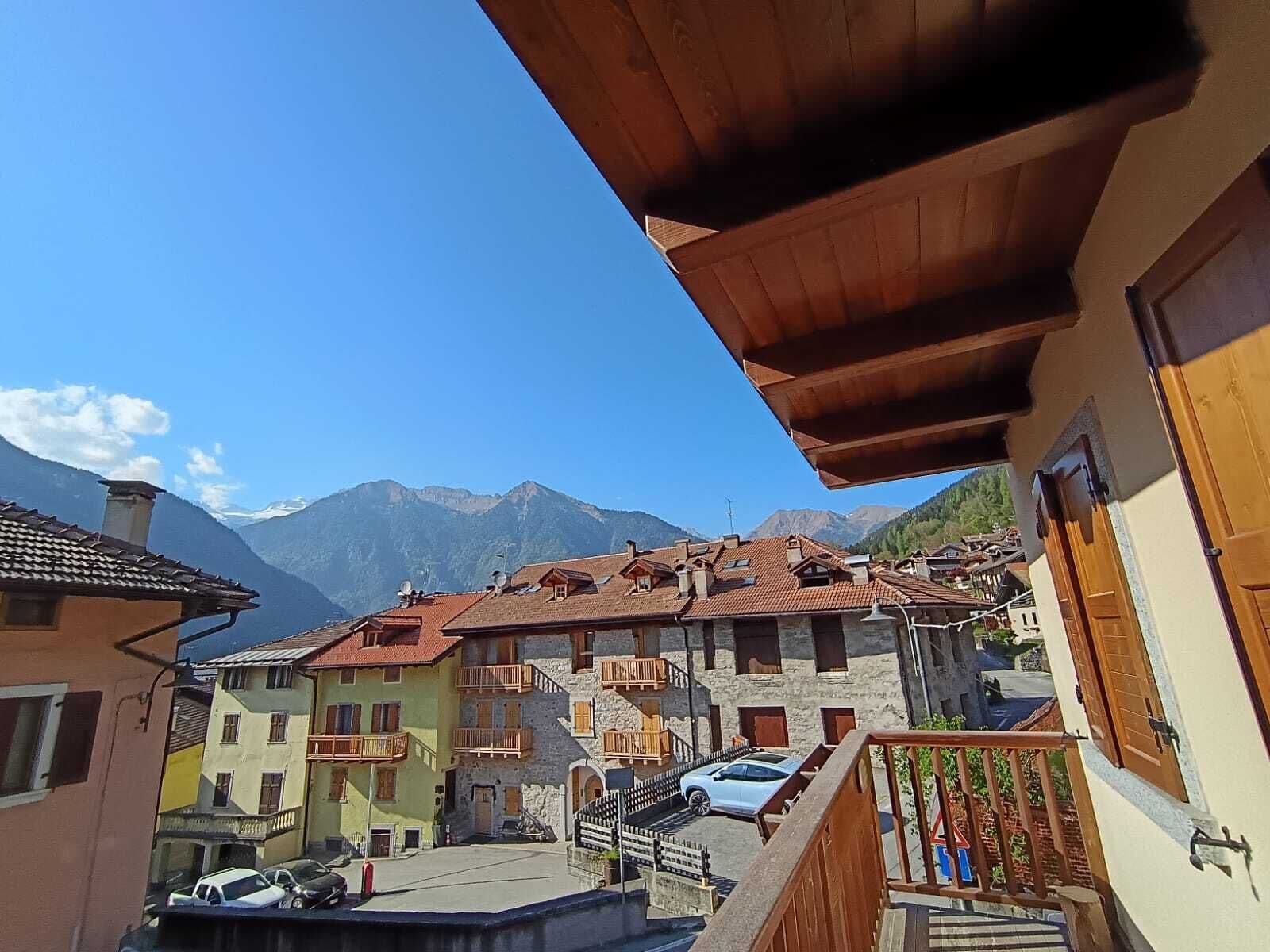 A traditional European village with stone buildings, balconies, and a mountain backdrop.. Apartment Brenta - Dolomiti Alpine Homes