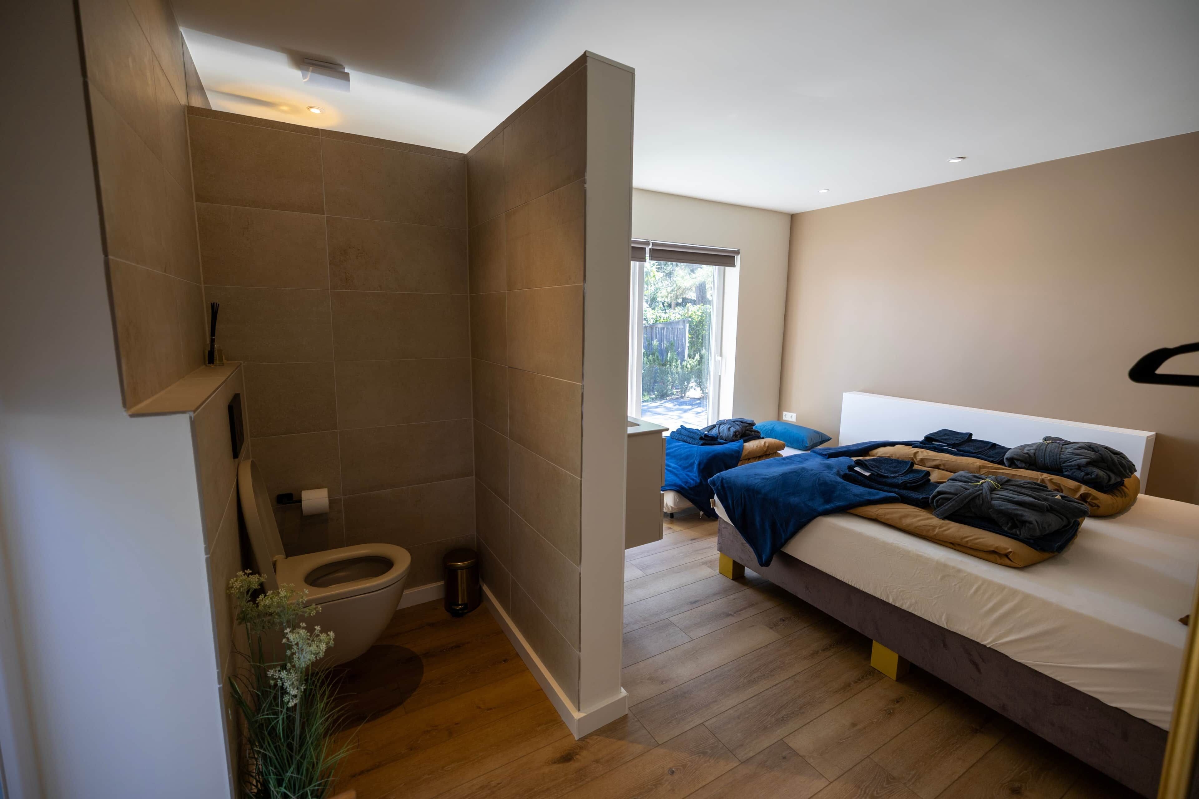 Ein modernes Badezimmer mit Dusche, Toilette und einer kleinen Pflanze.