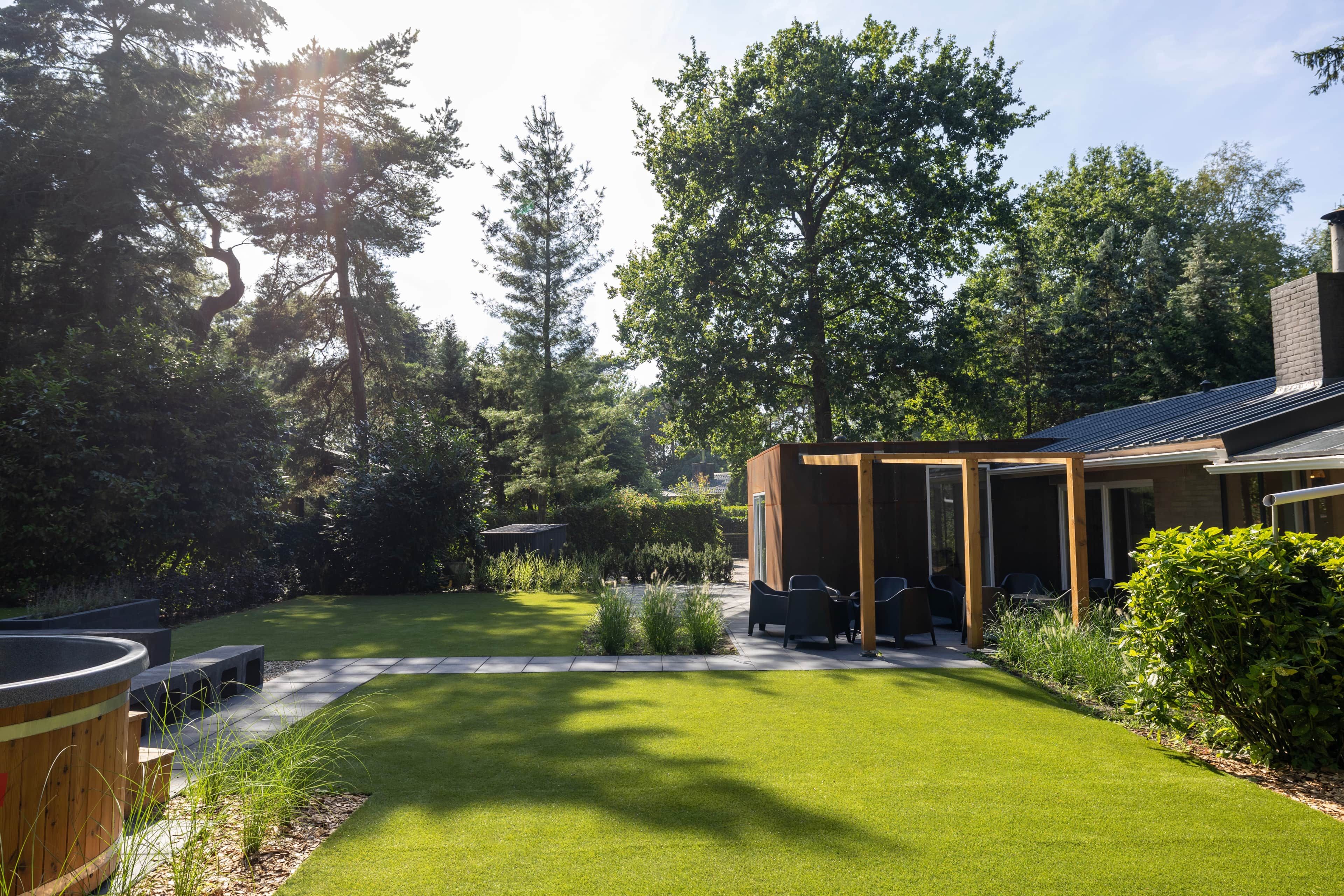A backyard with a patio, seating area, and a small building.
