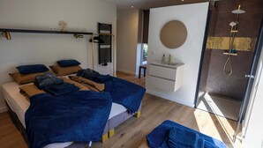 A modern bedroom with a bed, a bedside table, a mirror, a shower area, and a window. - ZEN-Bungalow no 7 with Forest serre, sauna and hottub (Rheezerveen)