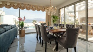 Uma sala de jantar moderna com uma mesa grande, cadeiras e um candelabro.
