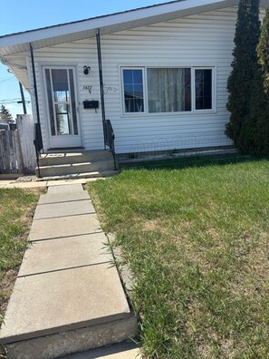 A single-story house with a front porch, a mailbox, and a number '1422' on the door.
