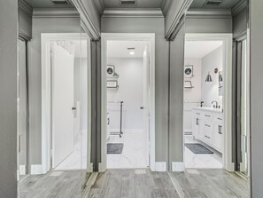 Un baño moderno con tocador, espejo y perchero.