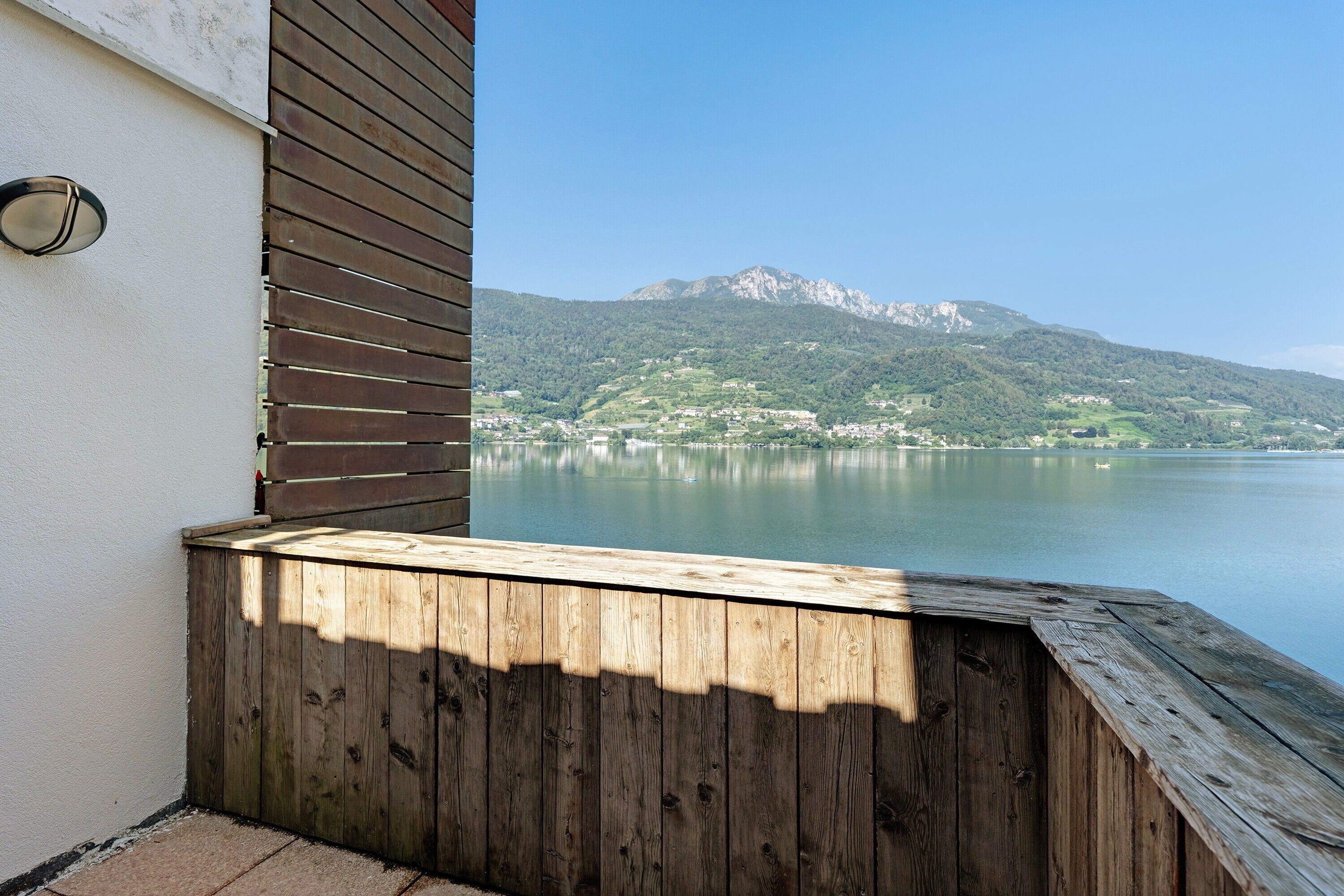 Un ponte di legno con vista su un lago e montagne sullo sfondo.