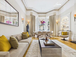 Ein geräumiges Wohnzimmer mit einer großen Couch, einem Couchtisch und einem Essbereich mit Stühlen.
