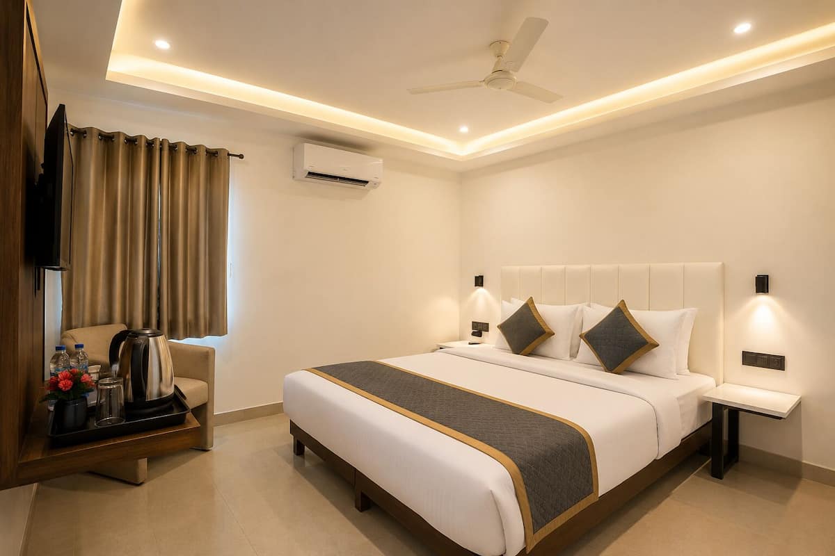 Una habitación de hotel con cama, mesitas de noche, ventilador de techo, aire acondicionado y una ventana con cortinas.