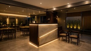 A modern interior with a reception desk, seating area, and indoor plants. - Hotel BlueBell Gachibowli By OTABoostup (Hyderabad)