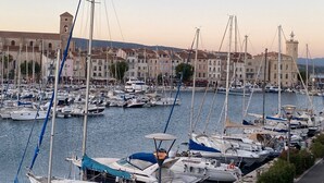 Ein Yachthafen mit zahlreichen Segelbooten, umgeben von historischen Gebäuden und einem markanten Turm.