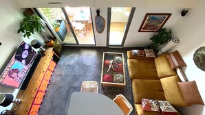 Ein Interieur mit einer Couch, einem Esstisch, einer Pflanze und einem Plattenspieler.
