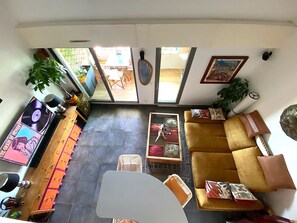 Een interieur met een bank, een eettafel, een plant en een platenspeler.