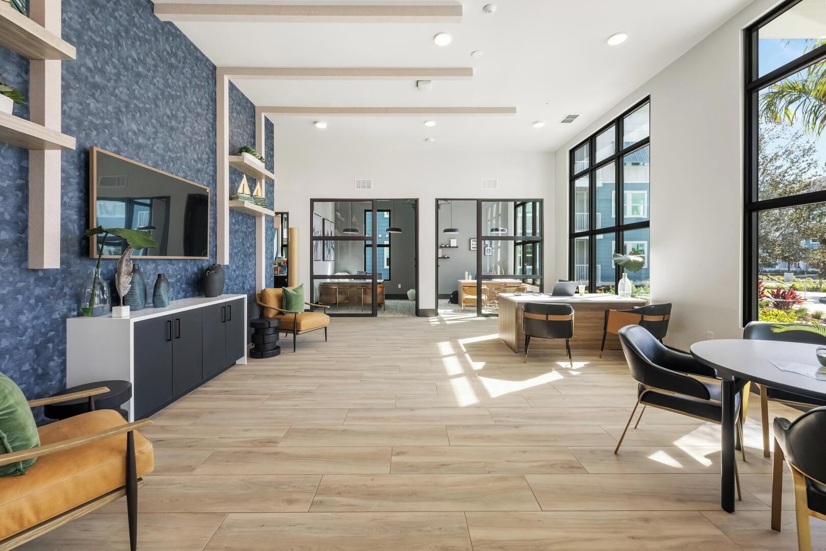 Ein modernes Interieur mit Küche, Essbereich und großen Fenstern.