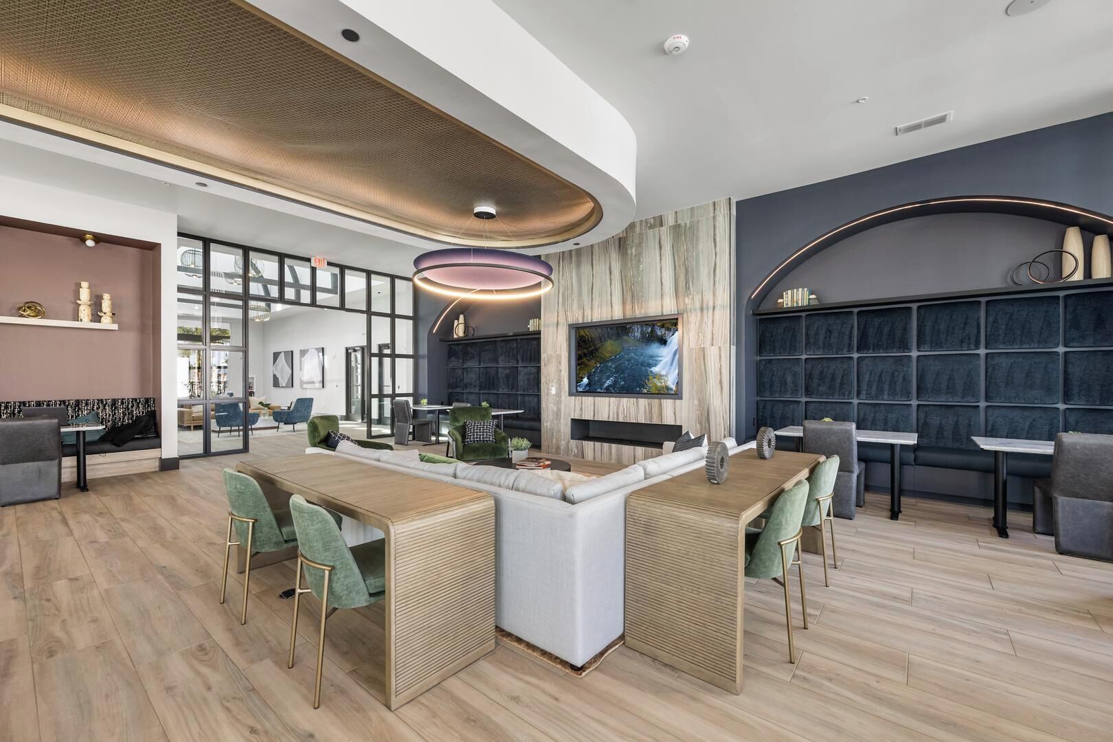 A modern bar area with a central island, seating arrangements, and a large TV screen.