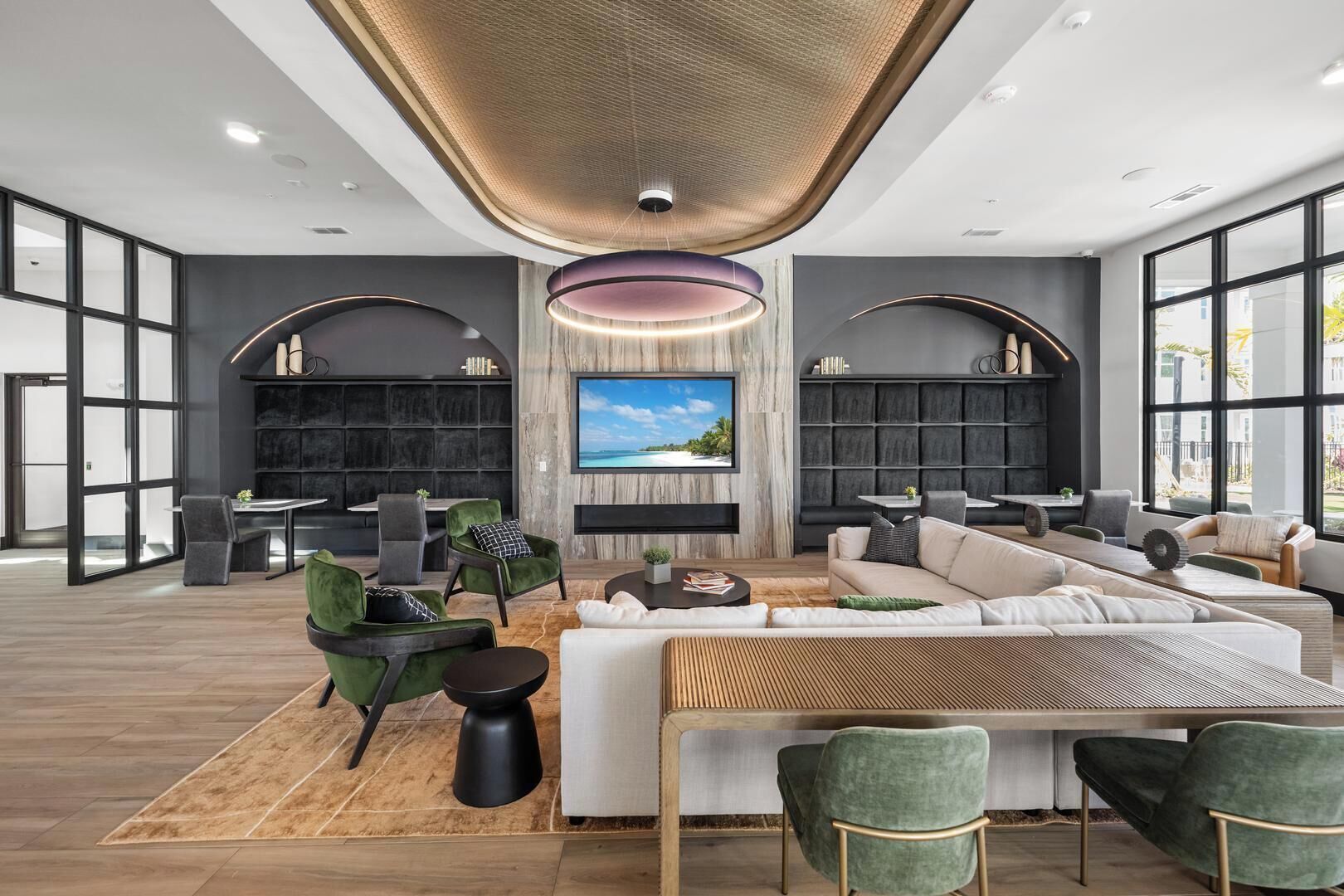 A modern living room with a large sofa, a coffee table, and a TV mounted on the wall.