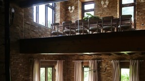 A spacious living room with a high ceiling, a fireplace, a sofa set, and a dining area with chairs. - Luxury house in front of the valley, 20 minutes from Las Catedrales beach. (San Tirso de Abres)