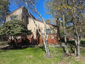 A two-story house with a wooden deck and a stone foundation. - Quiet Poconos Chalet with Loft Lounge (ALBRIGHTSVLLE)