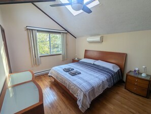 A bedroom with a bed, a desk, a chair, a nightstand, and a ceiling fan. - Quiet Poconos Chalet with Loft Lounge (ALBRIGHTSVLLE)